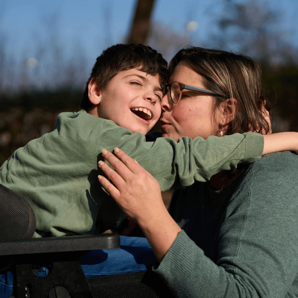 Boy with cerebral palsy hugging his mum