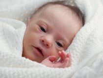 Young baby wrapped up in a white blanket 
