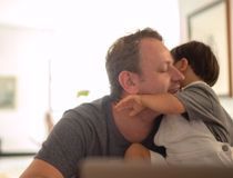 A man cuddling a young boy