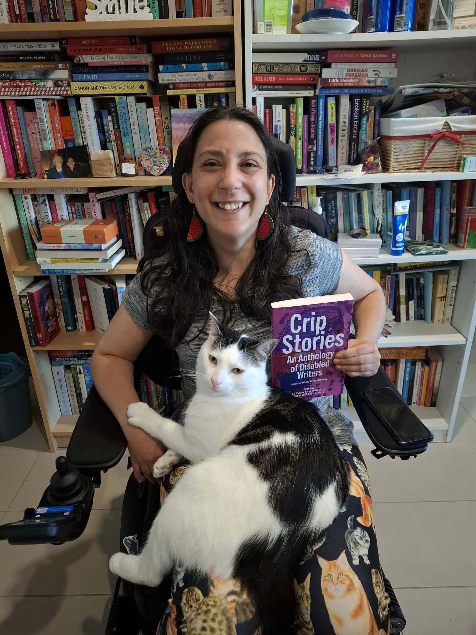 Lady holding a book next to her cat